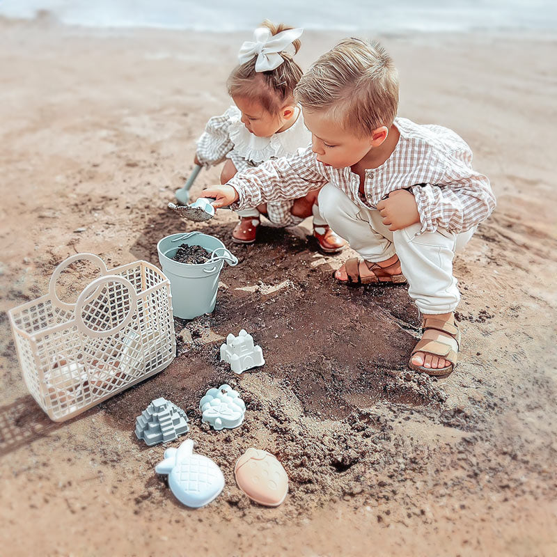 Zwei Kinder spielen mit dem Moonkie Strandspielzeugset.